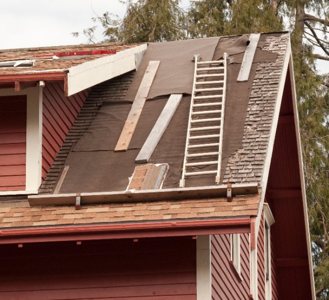 Old cedar shingles being removed and new shingles being installed.