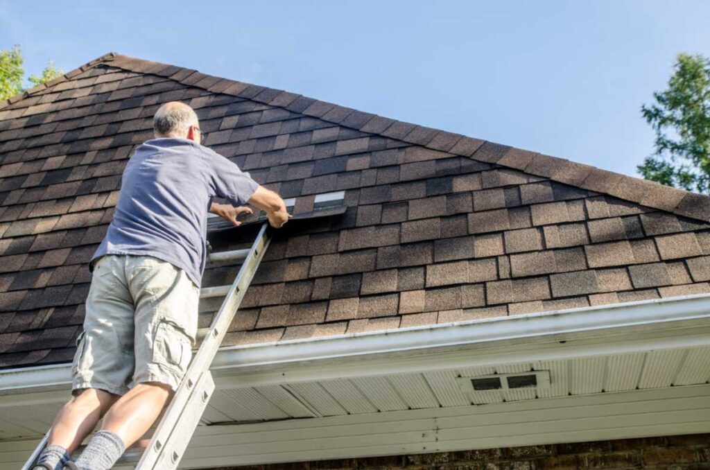 Homeowner repairing an asphalt shingle roof on a house in Portland, OR