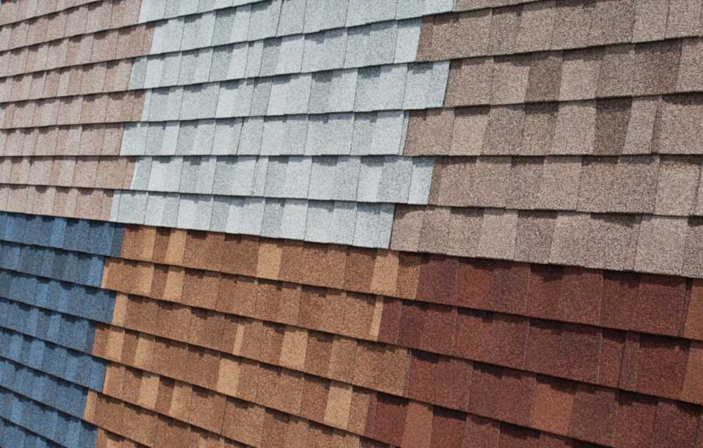 Different types of composite roof shingles in various colors and textures arranged in rows